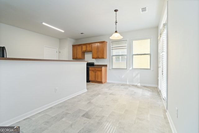 kitchen with pendant lighting, refrigerator, and black stove