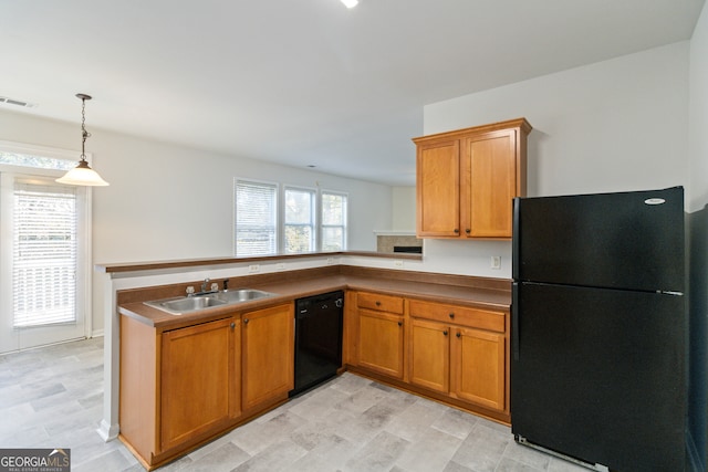 kitchen with kitchen peninsula, sink, decorative light fixtures, and black appliances