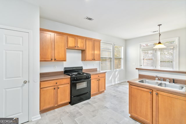 kitchen with black gas stove, hanging light fixtures, and sink