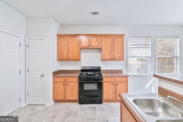 kitchen featuring light hardwood / wood-style floors, sink, and black gas range oven