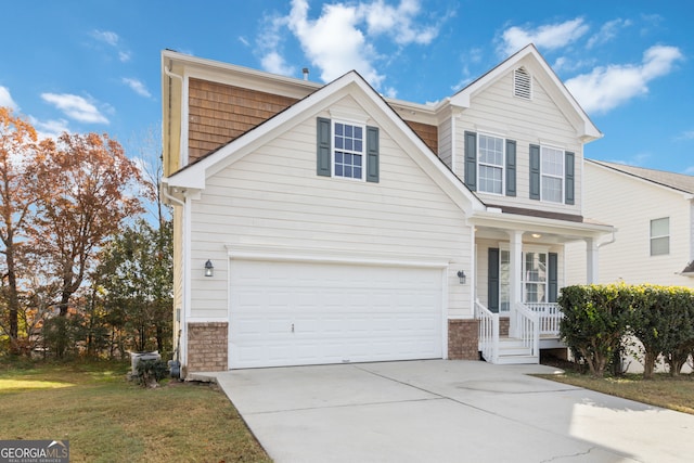 view of front property featuring covered porch, a front yard, and a garage