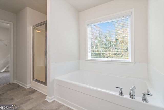 bathroom featuring hardwood / wood-style floors and shower with separate bathtub