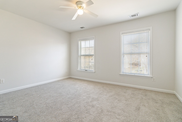 carpeted spare room with ceiling fan and a wealth of natural light