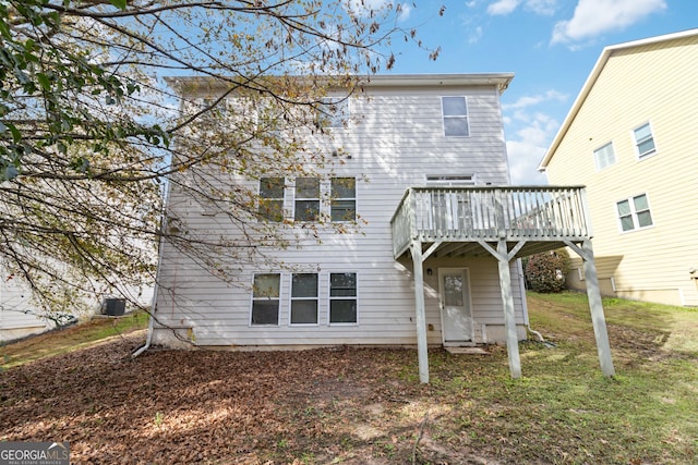 rear view of house featuring a deck and a lawn