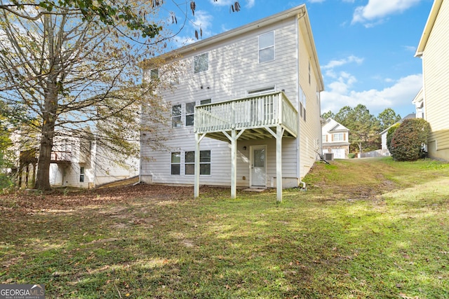 rear view of property featuring a yard, central AC, and a wooden deck