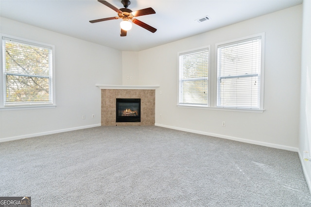 unfurnished living room with a fireplace, carpet floors, and a healthy amount of sunlight