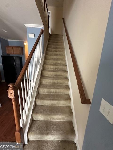 stairway featuring ornamental molding