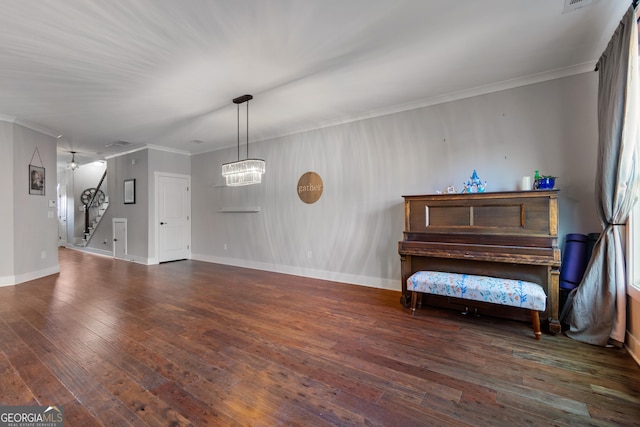 interior space with dark hardwood / wood-style flooring, ornamental molding, and an inviting chandelier