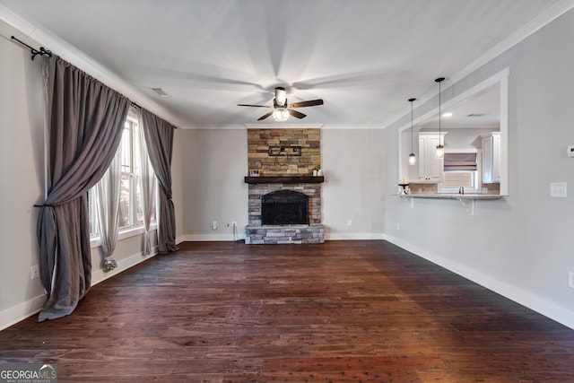 unfurnished living room with dark hardwood / wood-style floors, ceiling fan, a stone fireplace, and ornamental molding