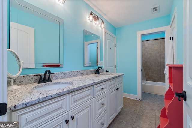 bathroom featuring tile patterned flooring, vanity, and tiled shower / bath