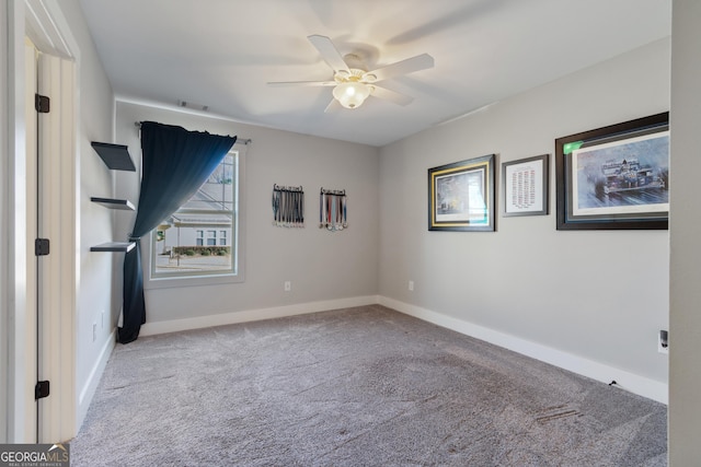 carpeted spare room featuring ceiling fan