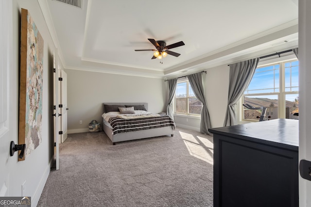 carpeted bedroom featuring a tray ceiling, ceiling fan, and crown molding