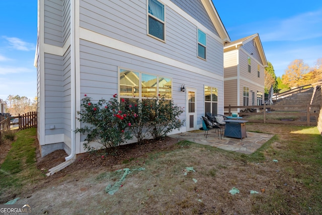 back of property with a yard and a patio