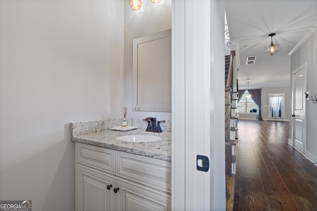 bathroom featuring hardwood / wood-style floors, vanity, and ornamental molding