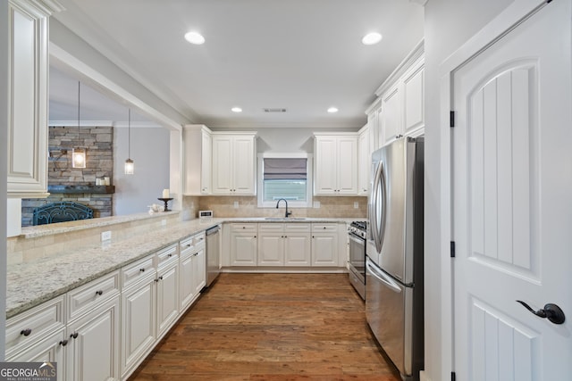 kitchen featuring stainless steel appliances, dark hardwood / wood-style flooring, backsplash, kitchen peninsula, and white cabinets