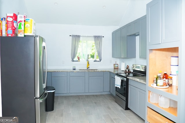 kitchen featuring sink, light stone countertops, and stainless steel appliances