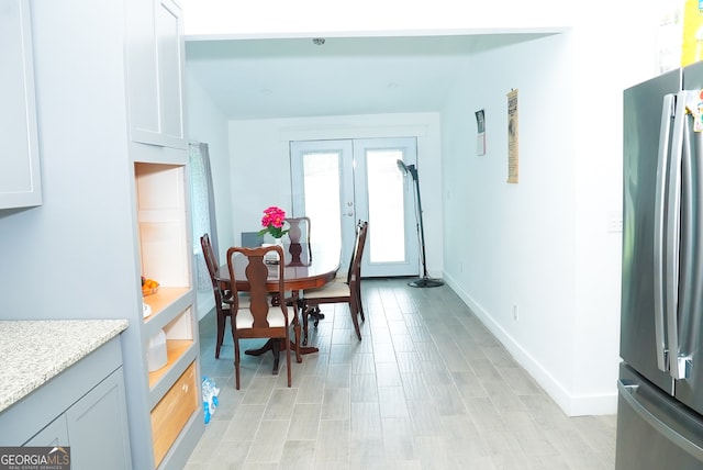 dining space featuring french doors and light hardwood / wood-style floors