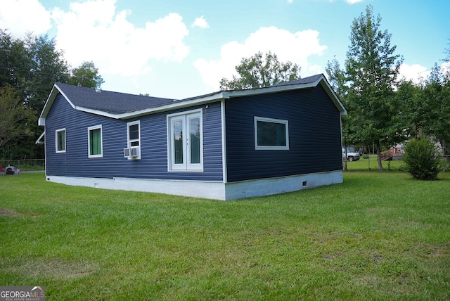 rear view of house featuring a lawn and cooling unit