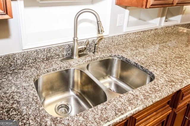 room details featuring light stone counters and sink