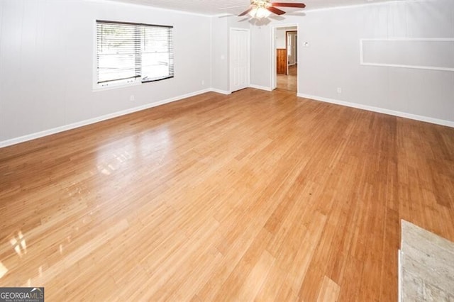 empty room featuring ceiling fan and light hardwood / wood-style flooring