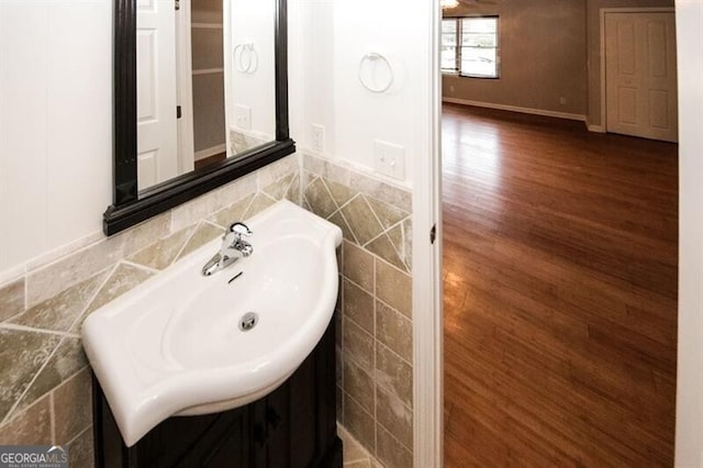 bathroom featuring hardwood / wood-style flooring, tile walls, and sink