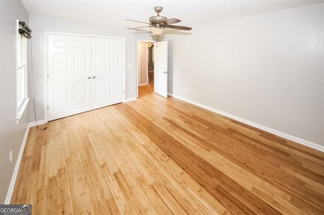 unfurnished bedroom featuring a closet, light hardwood / wood-style flooring, and ceiling fan