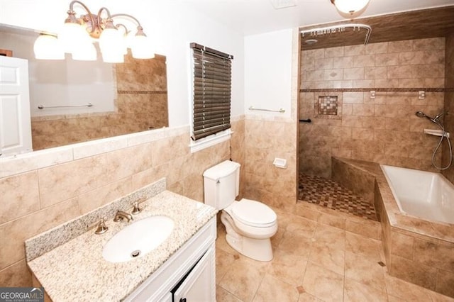 full bathroom featuring vanity, toilet, tile walls, and independent shower and bath