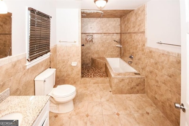 full bathroom with tile patterned flooring, vanity, toilet, and tile walls