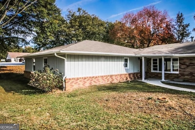 view of side of home with a yard