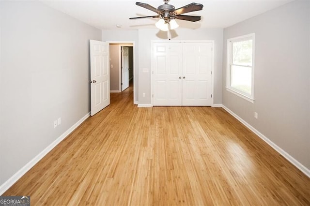 unfurnished bedroom featuring ceiling fan, a closet, and light hardwood / wood-style floors