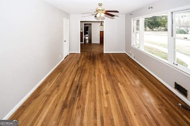 empty room featuring dark hardwood / wood-style flooring and ceiling fan