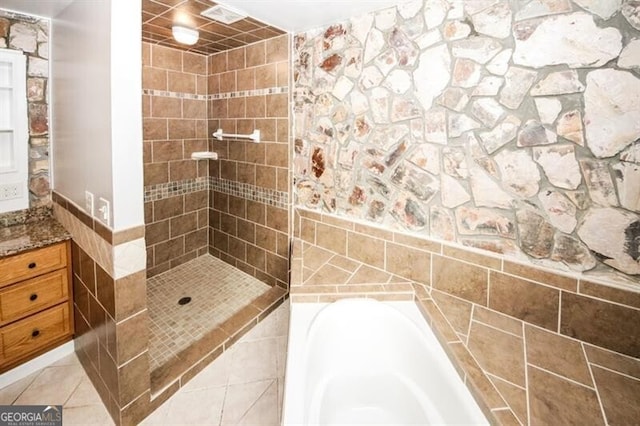 bathroom featuring tile walls and independent shower and bath