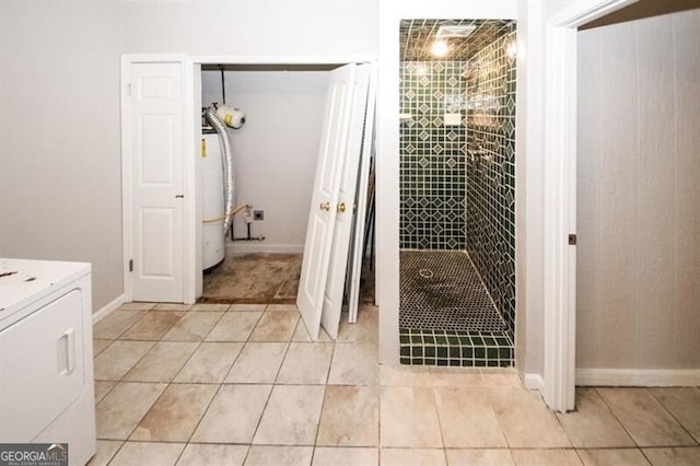 bathroom featuring tile patterned floors, tiled shower, and washer / clothes dryer