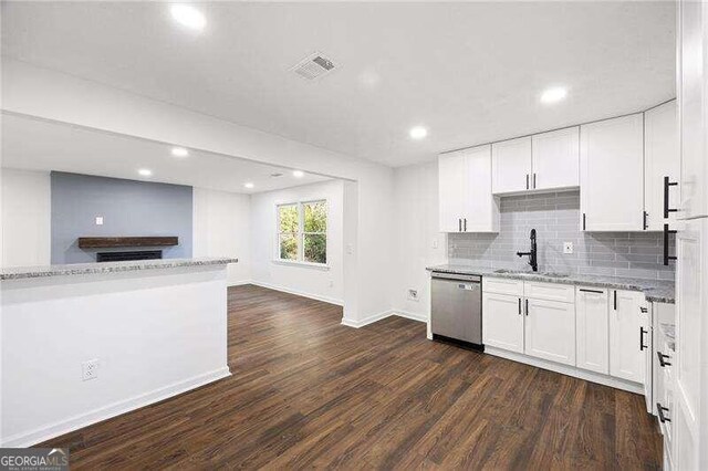 kitchen featuring dark hardwood / wood-style flooring, light stone counters, stainless steel dishwasher, sink, and white cabinets