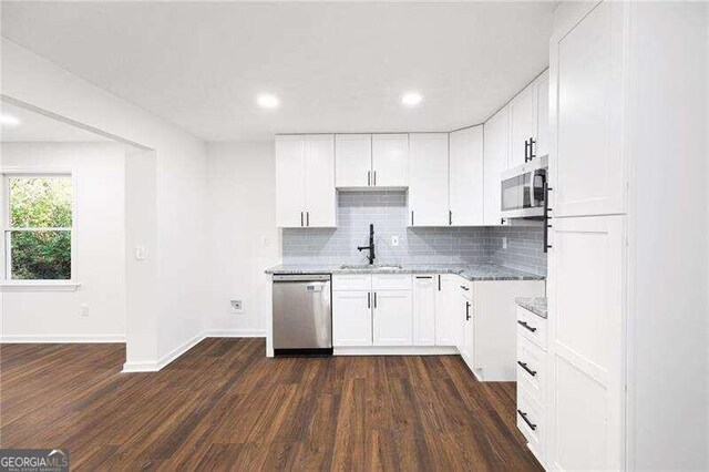 kitchen featuring white cabinets, stainless steel appliances, and dark wood-type flooring