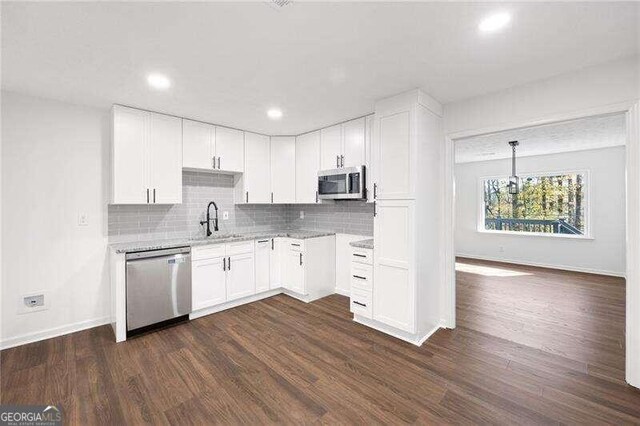 kitchen featuring sink, stainless steel appliances, dark hardwood / wood-style flooring, pendant lighting, and white cabinets