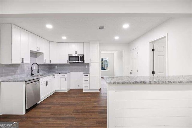 kitchen featuring stainless steel appliances, white cabinetry, dark wood-type flooring, and sink