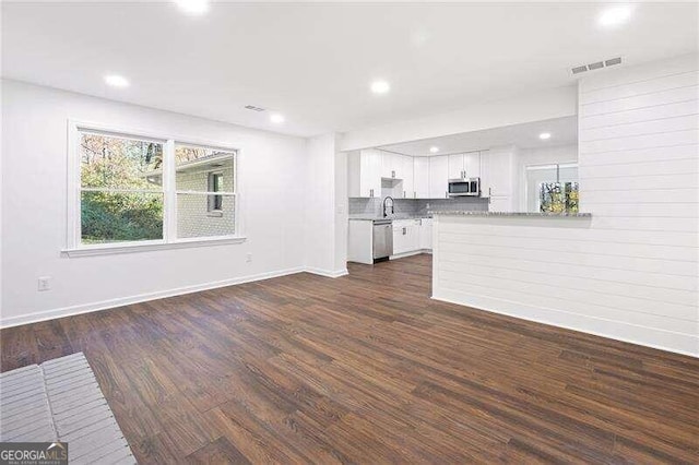 unfurnished living room with dark hardwood / wood-style floors and sink