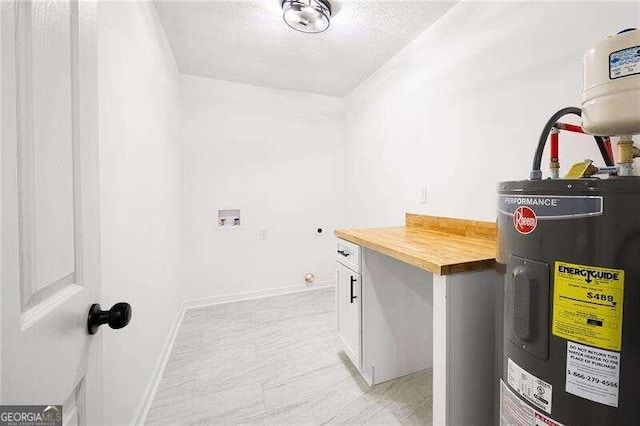 laundry room featuring electric water heater, cabinets, and a textured ceiling