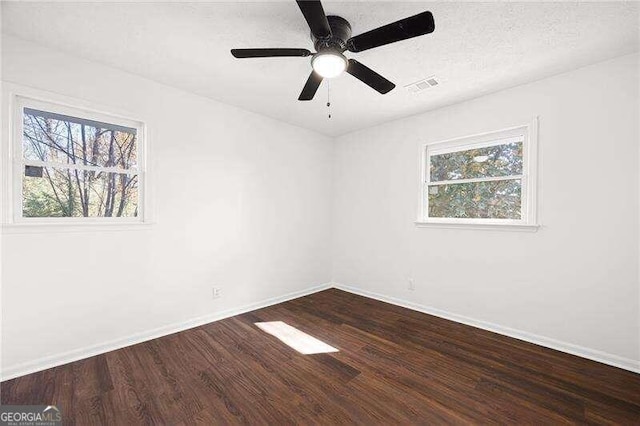 spare room with ceiling fan, dark wood-type flooring, and a textured ceiling