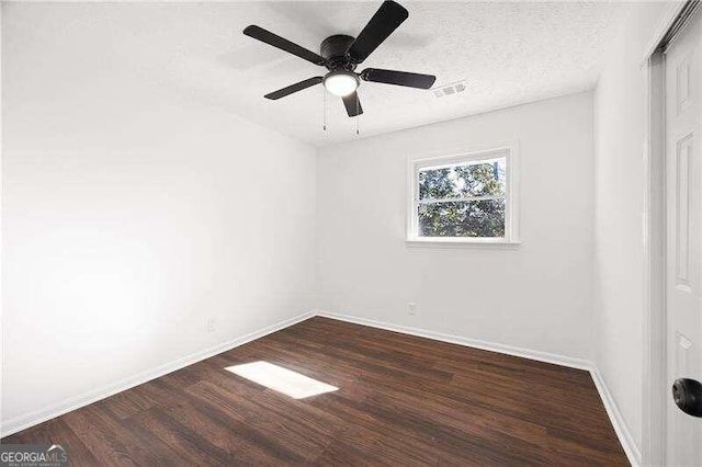 empty room featuring a textured ceiling, ceiling fan, and dark hardwood / wood-style floors