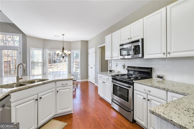 kitchen with white cabinets, sink, stainless steel appliances, and hardwood / wood-style flooring