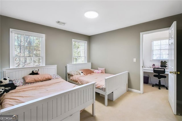 bedroom with light colored carpet and multiple windows