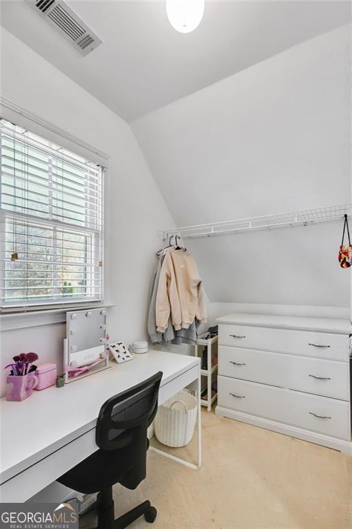 office space featuring lofted ceiling and light carpet