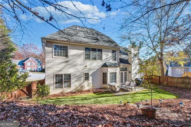 rear view of house with a yard and a patio