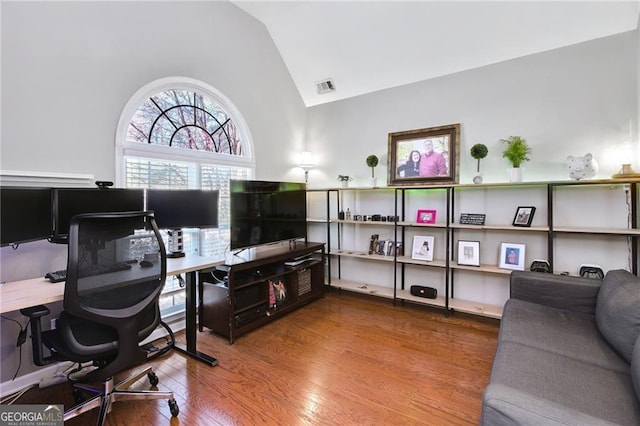 home office featuring high vaulted ceiling and hardwood / wood-style flooring