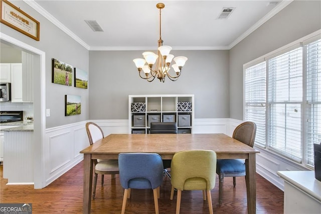 dining area featuring dark hardwood / wood-style floors, ornamental molding, and a chandelier