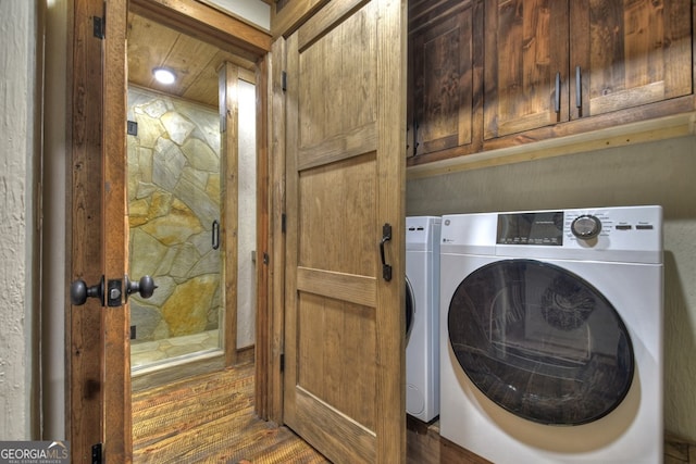 washroom featuring washer / clothes dryer, cabinets, and dark wood-type flooring