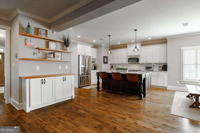 kitchen featuring a breakfast bar area, white cabinetry, a center island, and stainless steel appliances