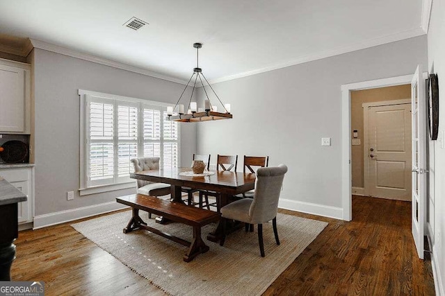 dining room with dark hardwood / wood-style flooring, crown molding, and an inviting chandelier